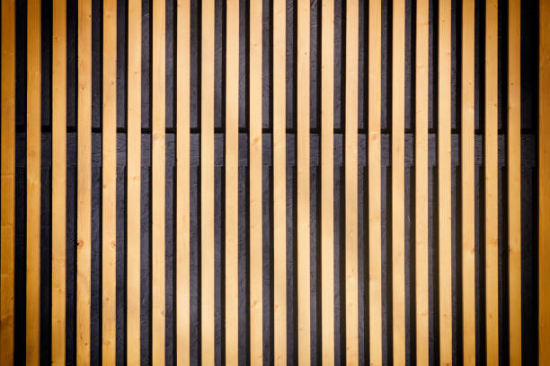 Wall of thin wooden slats. Vertical parallel plates. Empty background with vignette.